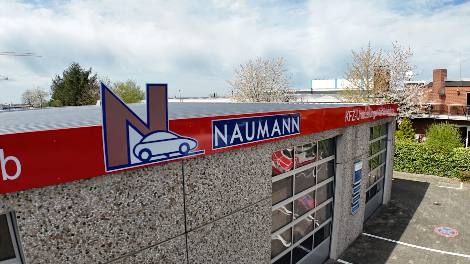 Naumann-Logo mit blühendem Kirschbaum aus der Drohnenperspektive